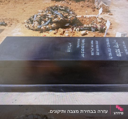 מצבה שחורה עם כיתוב בעברית בבית קברות